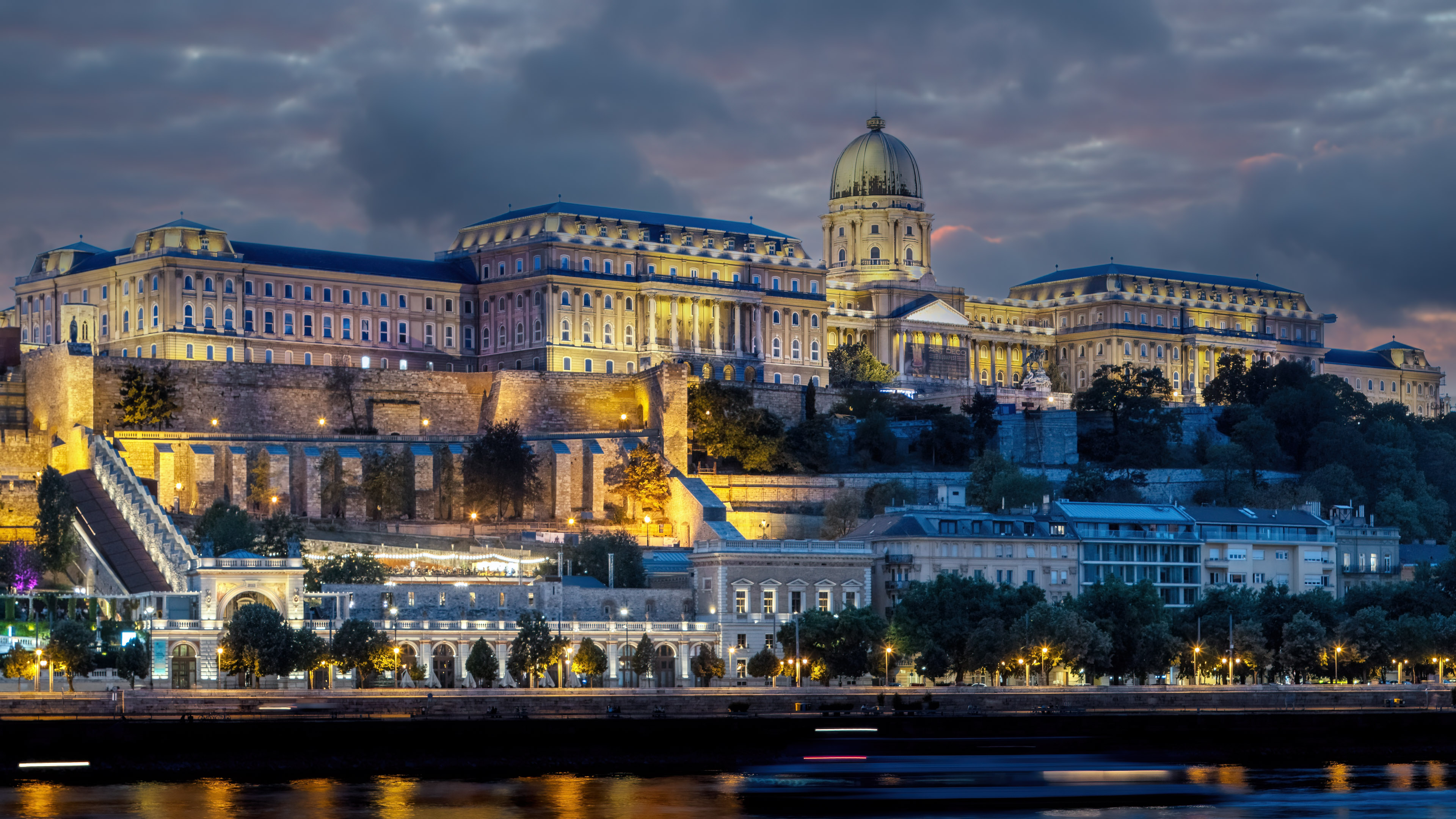 Enjoy the beauty of Budapest's cityscape at night with this stunning wallpaper. The colorful lights and breathtaking architecture will transform your screen into a work of art.