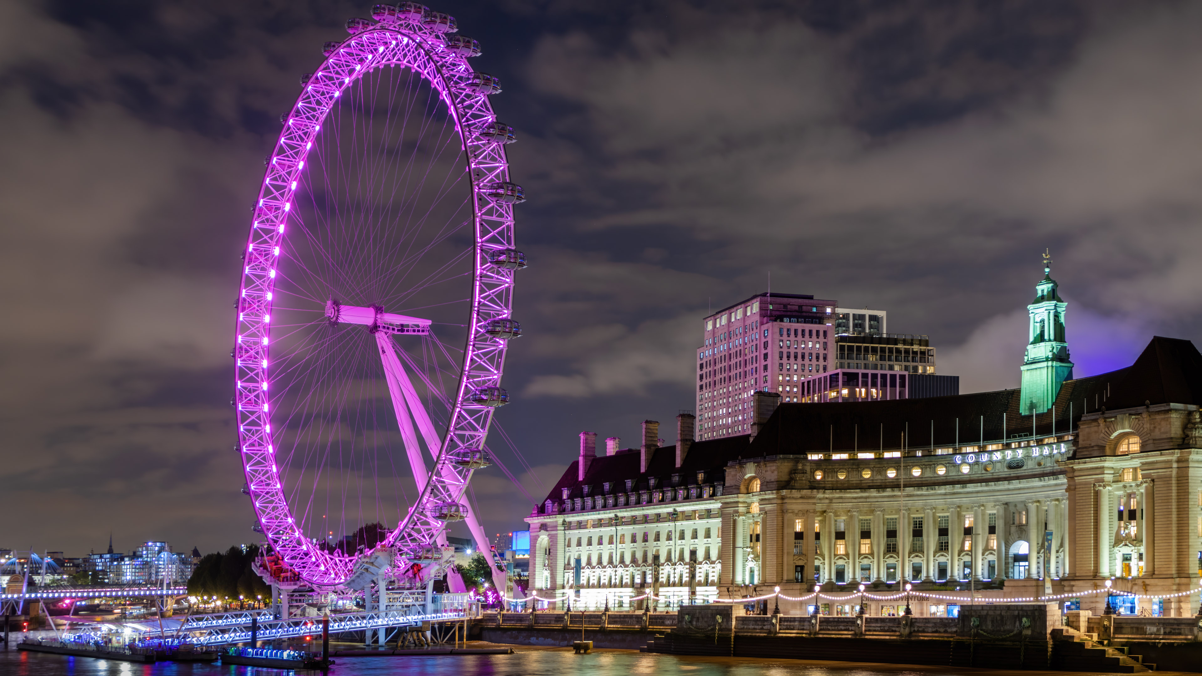 Vivez la magie de Londres la nuit avec notre fond d’écran 4K mettant en vedette le London Eye, illuminant votre écran avec l’horizon emblématique de la ville. 