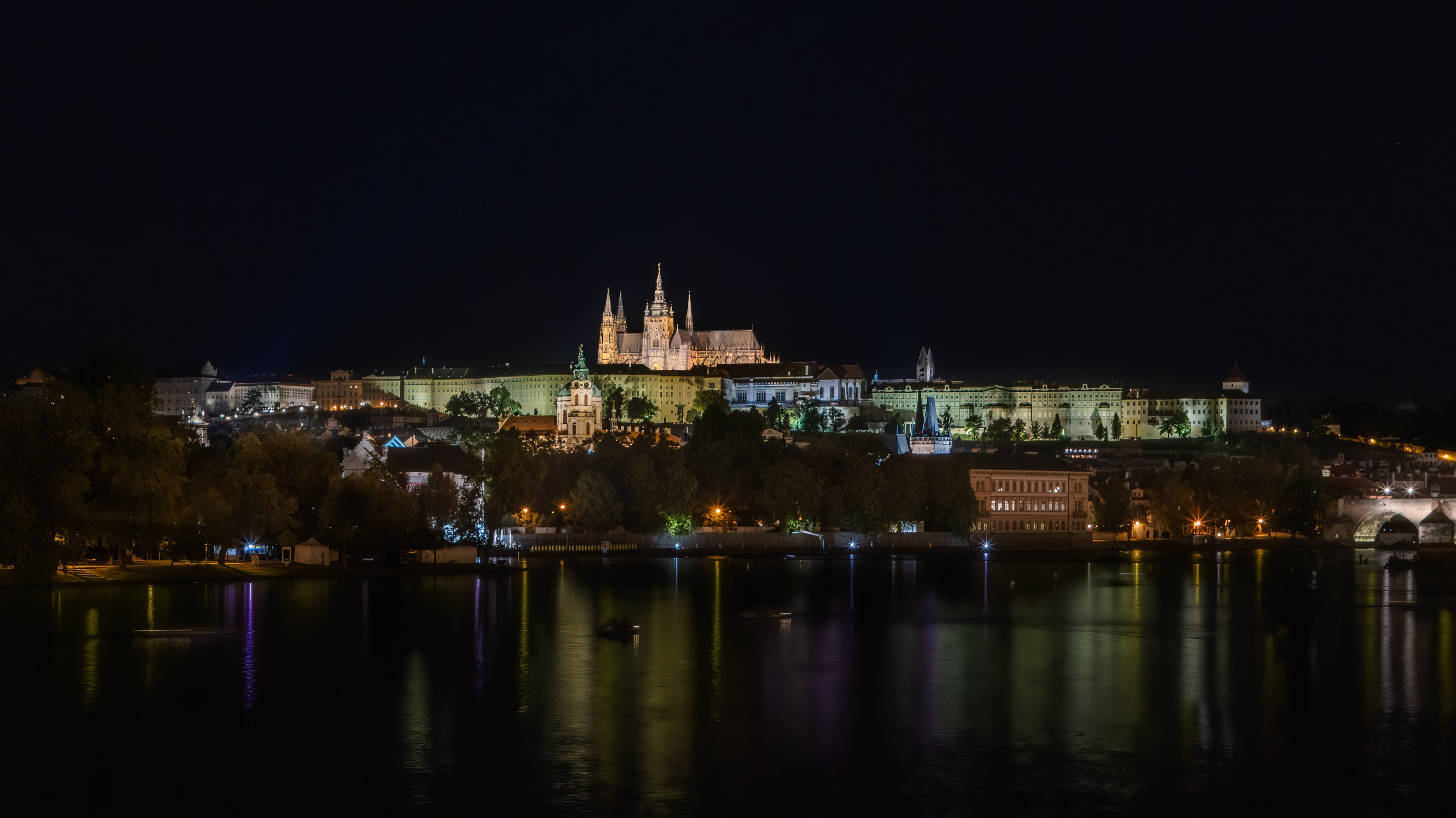This enchanting wallpaper captures the beauty of Prague at night with its colorful buildings and reflections on the water.