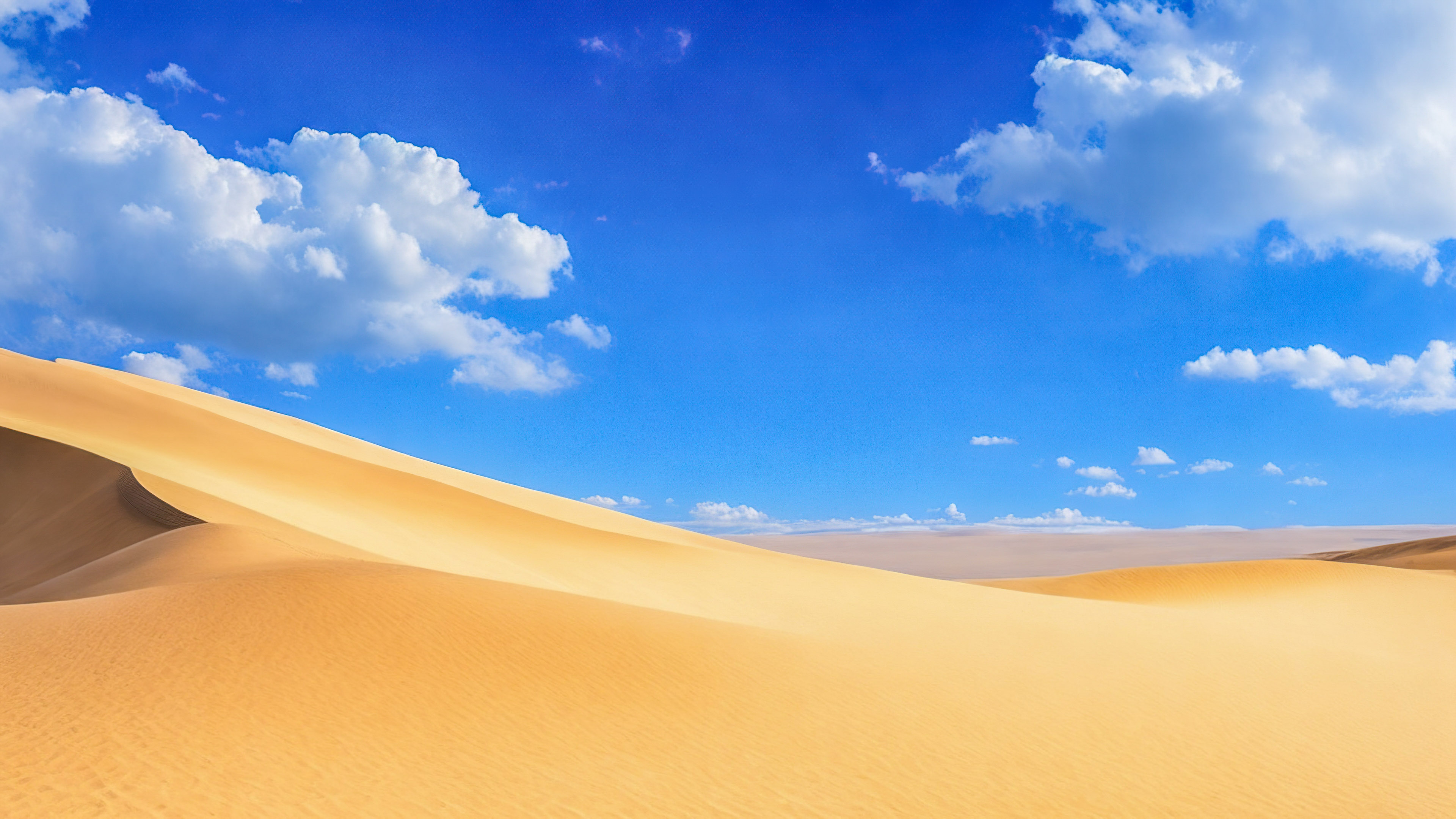Téléchargez la sérénité de notre fond d'écran de beaux paysages, présentant un paysage désertique serein avec des dunes de sable s'étendant jusqu'à l'horizon sous un vaste ciel bleu. 