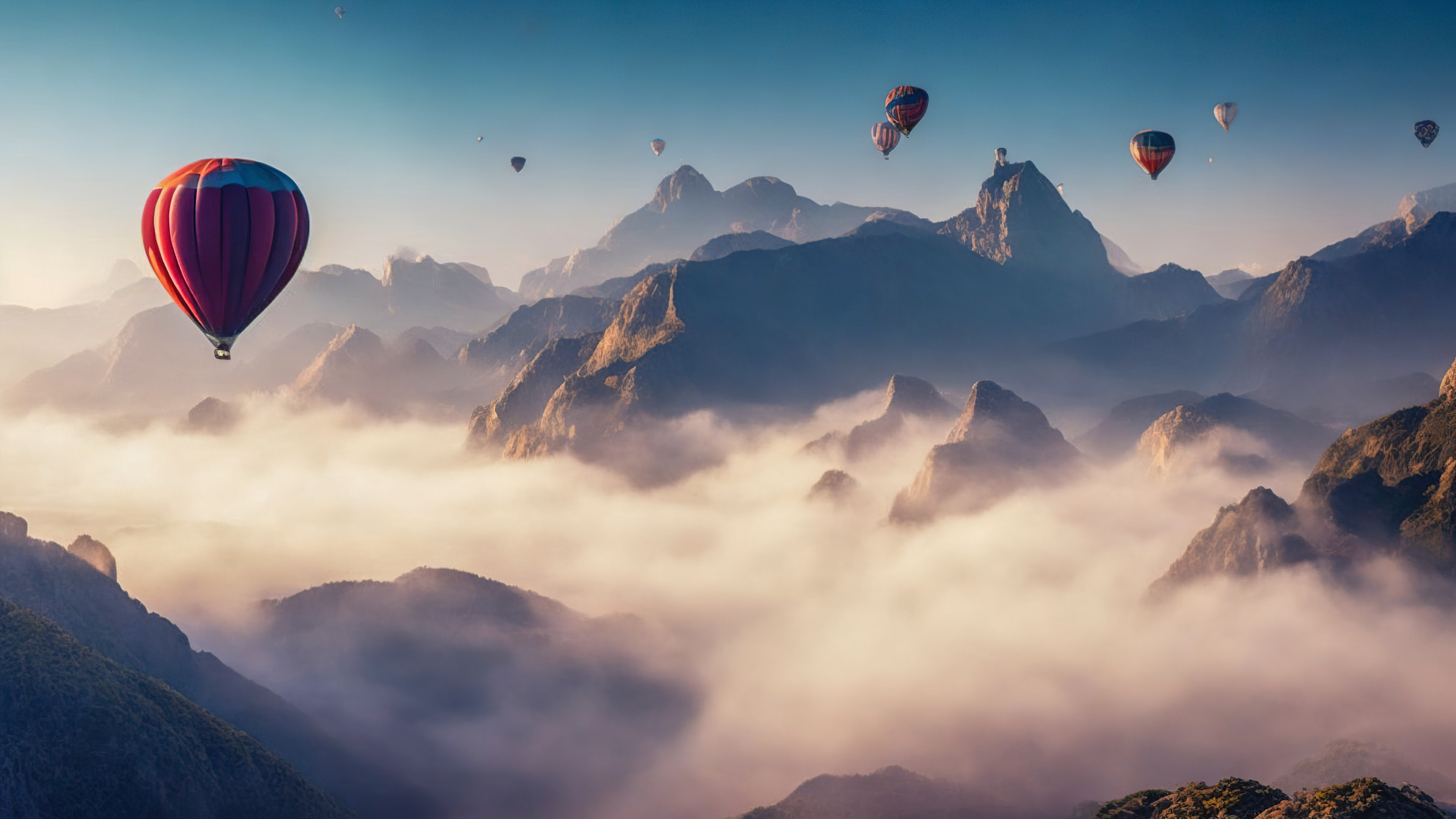Téléchargez le surréalisme avec notre fond d'écran de paysage de montagne, capturant un ciel surréaliste rempli de montgolfières flottant paisiblement au-dessus d'un paysage montagneux brumeux.