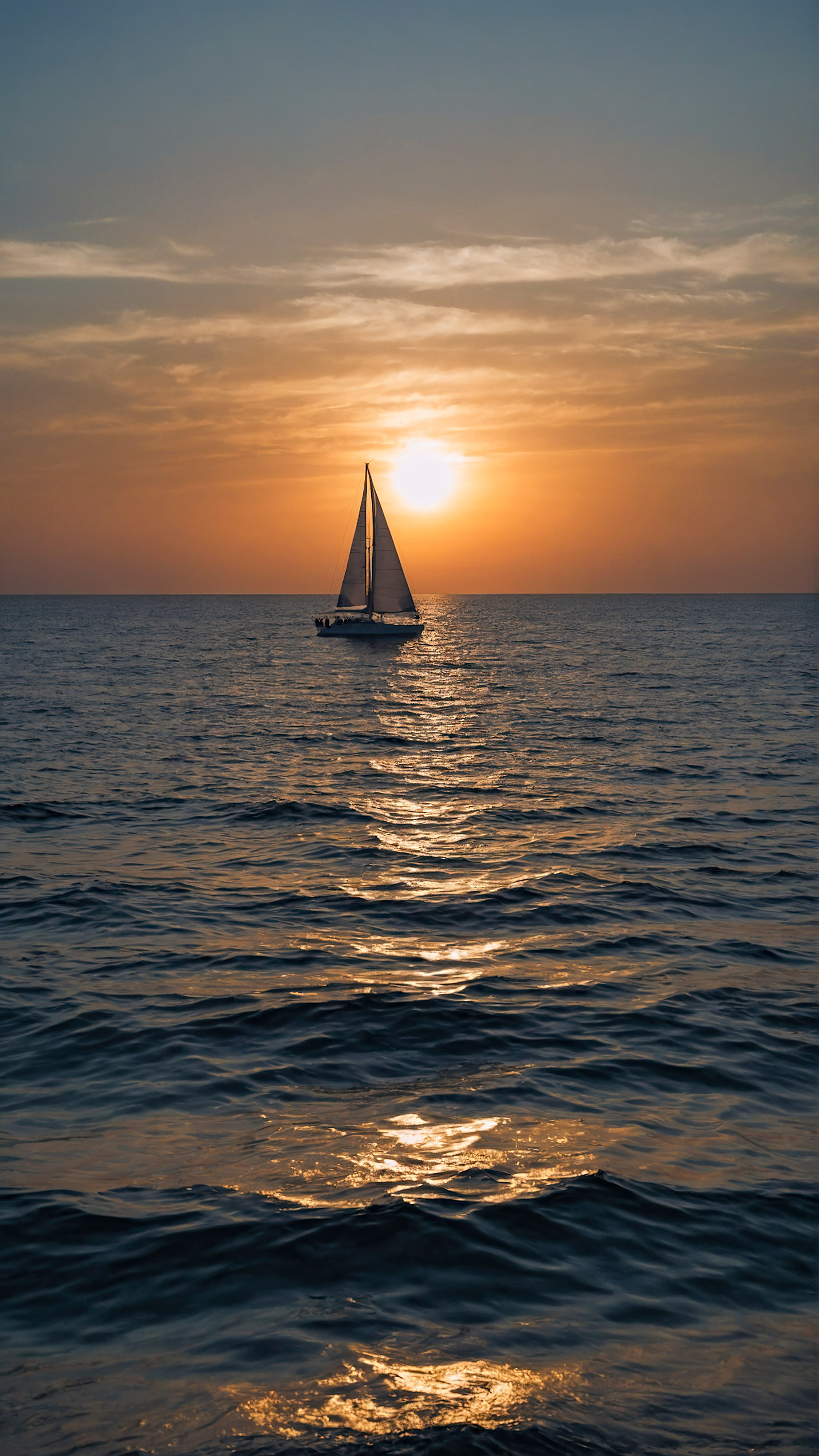 Apportez la beauté de l'océan à votre appareil avec un fond d'écran esthétique, dépeignant une vue sereine de l'océan sous un ciel de coucher de soleil en dégradé avec la silhouette d'un voilier distant.