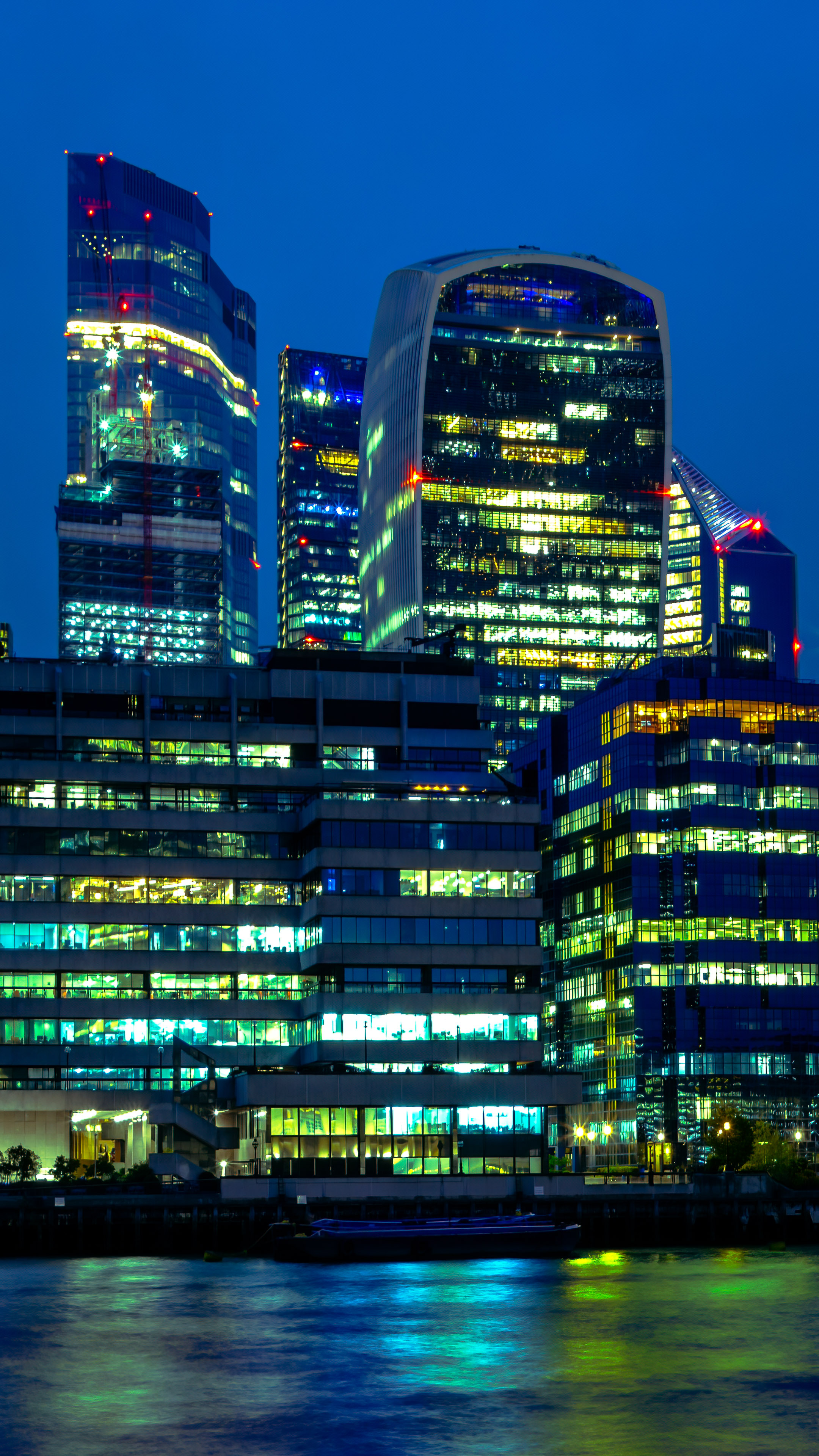 Illuminate your mobile screen with the dynamic city light wallpaper featuring London skyscrapers against a vibrant backdrop.