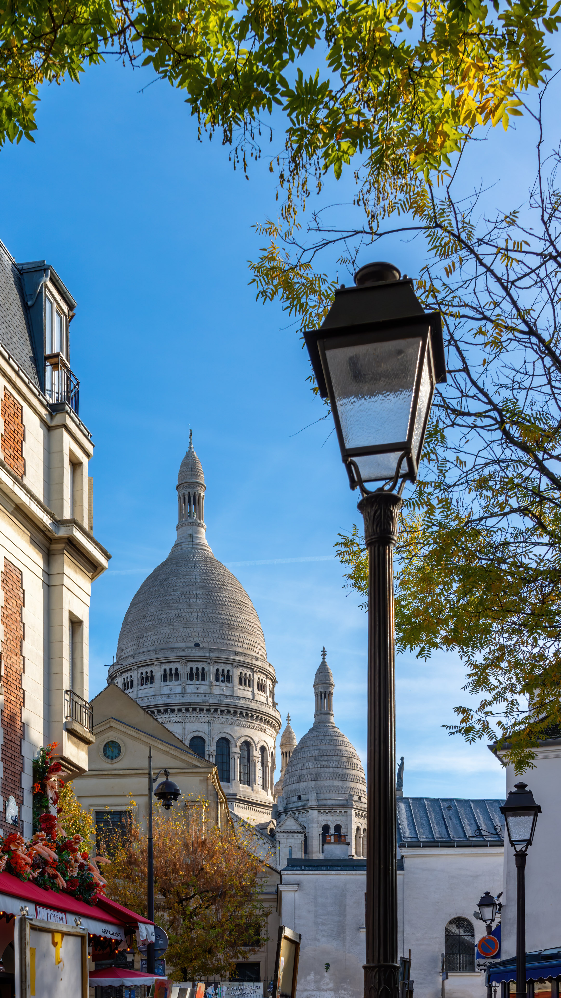 Experience the timeless beauty of Paris with this city background for iPhone featuring classic Parisian architecture and the Basilica of the Sacré-Cœur in the distance.
