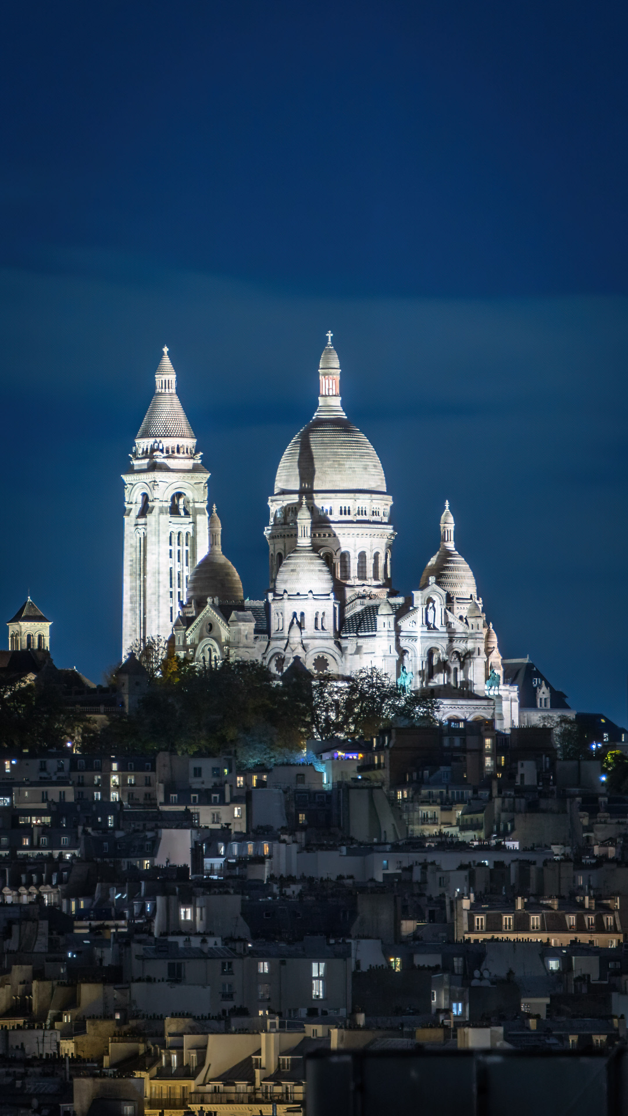 Experience the romantic allure of Montmartre in Paris at night with a beautiful cityscape, perfect for your mobile device.