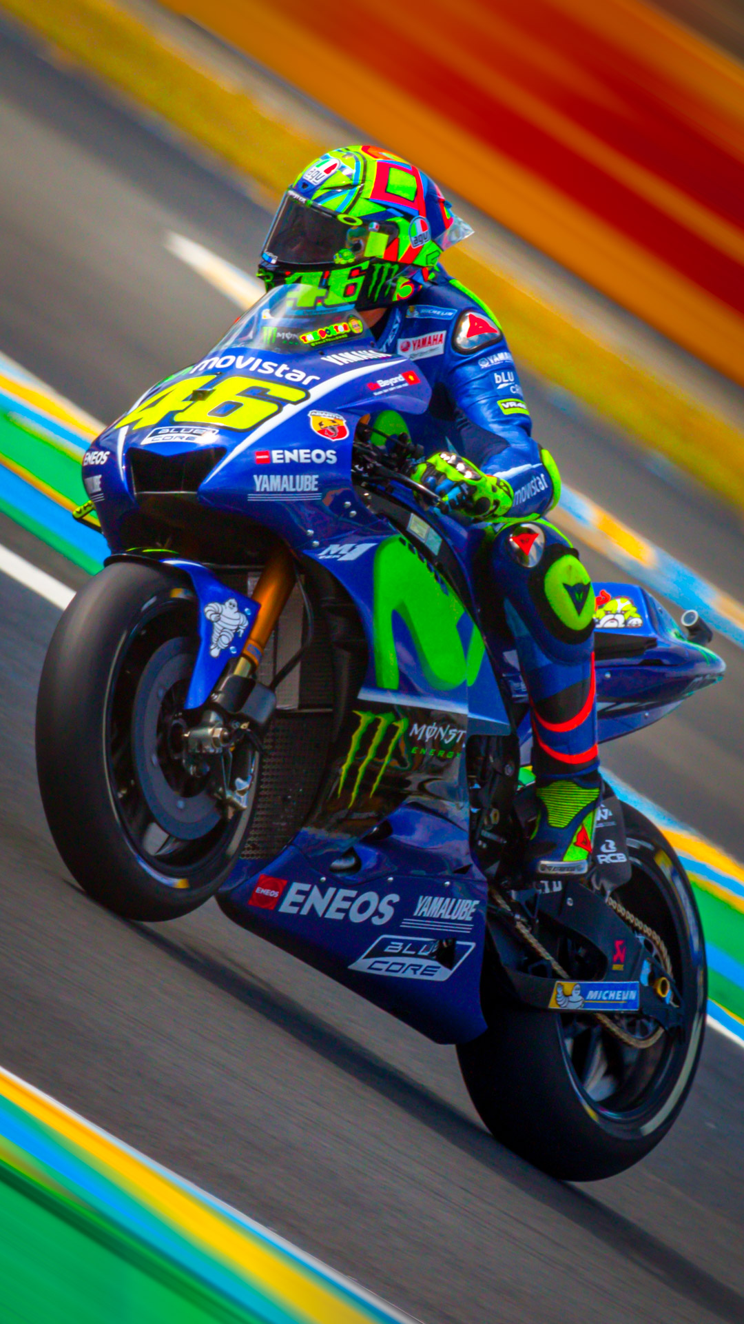 Feel the adrenaline rush with our free iPhone wallpaper featuring MotoGP rider Valentino Rossi, capturing the thrilling speed of the race.