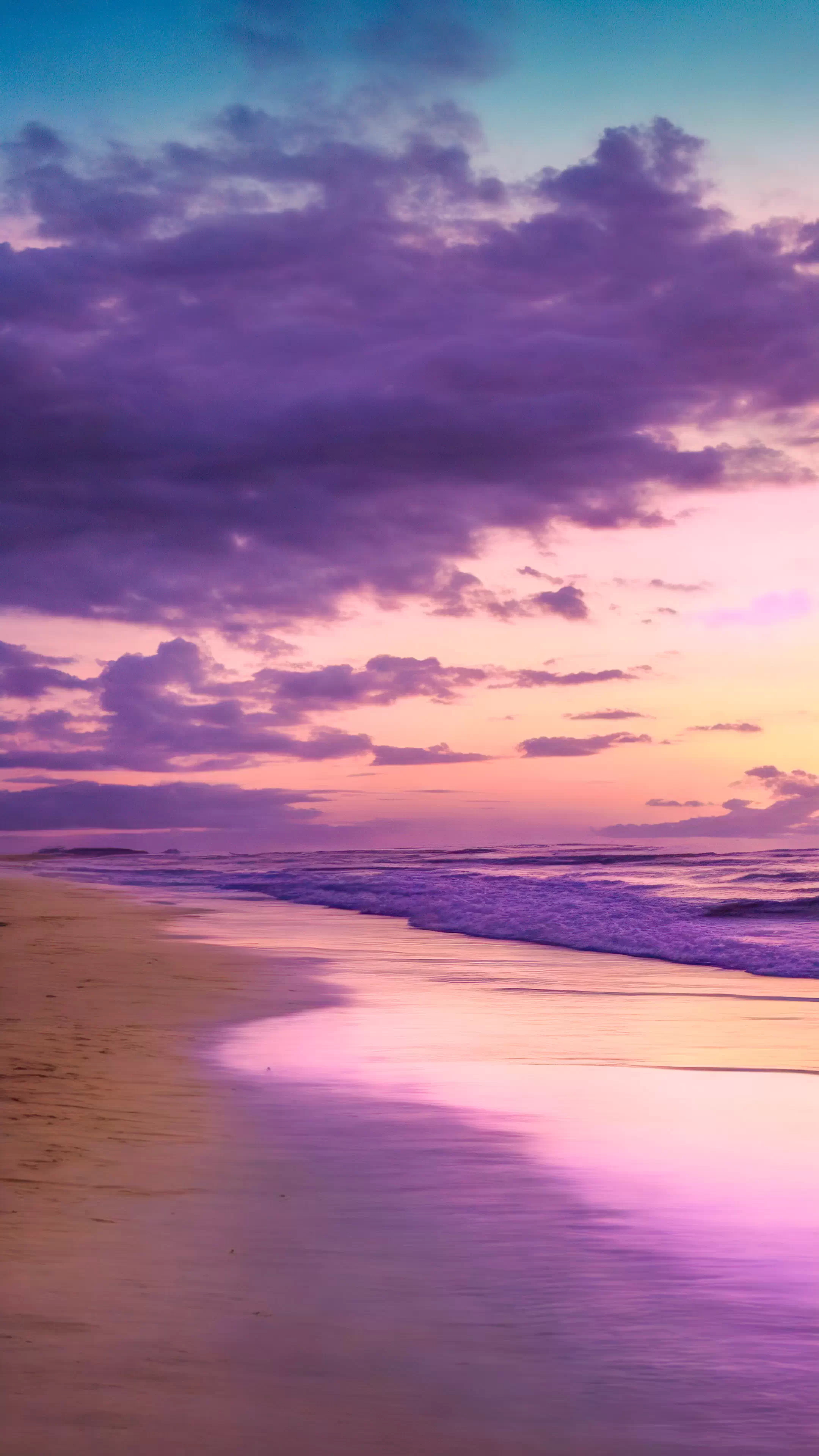 Download this nature wallpaper in HD for your iPhone, capturing a tranquil beach at twilight with a sky painted in shades of purple and pink, and let your screen become a window to a serene coastal sunset.