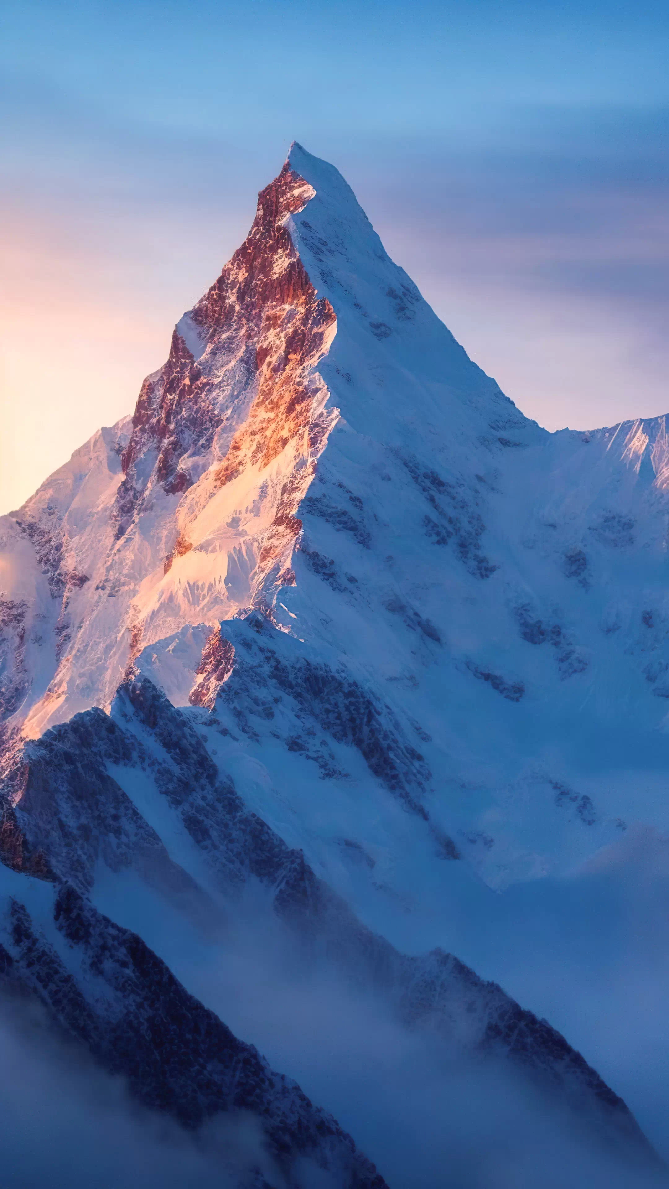 Experience the beauty of nature with our best nature wallpaper, featuring a captivating mountain bathed in the soft dawn light against a tranquil blue sky, bringing serenity to your digital world.