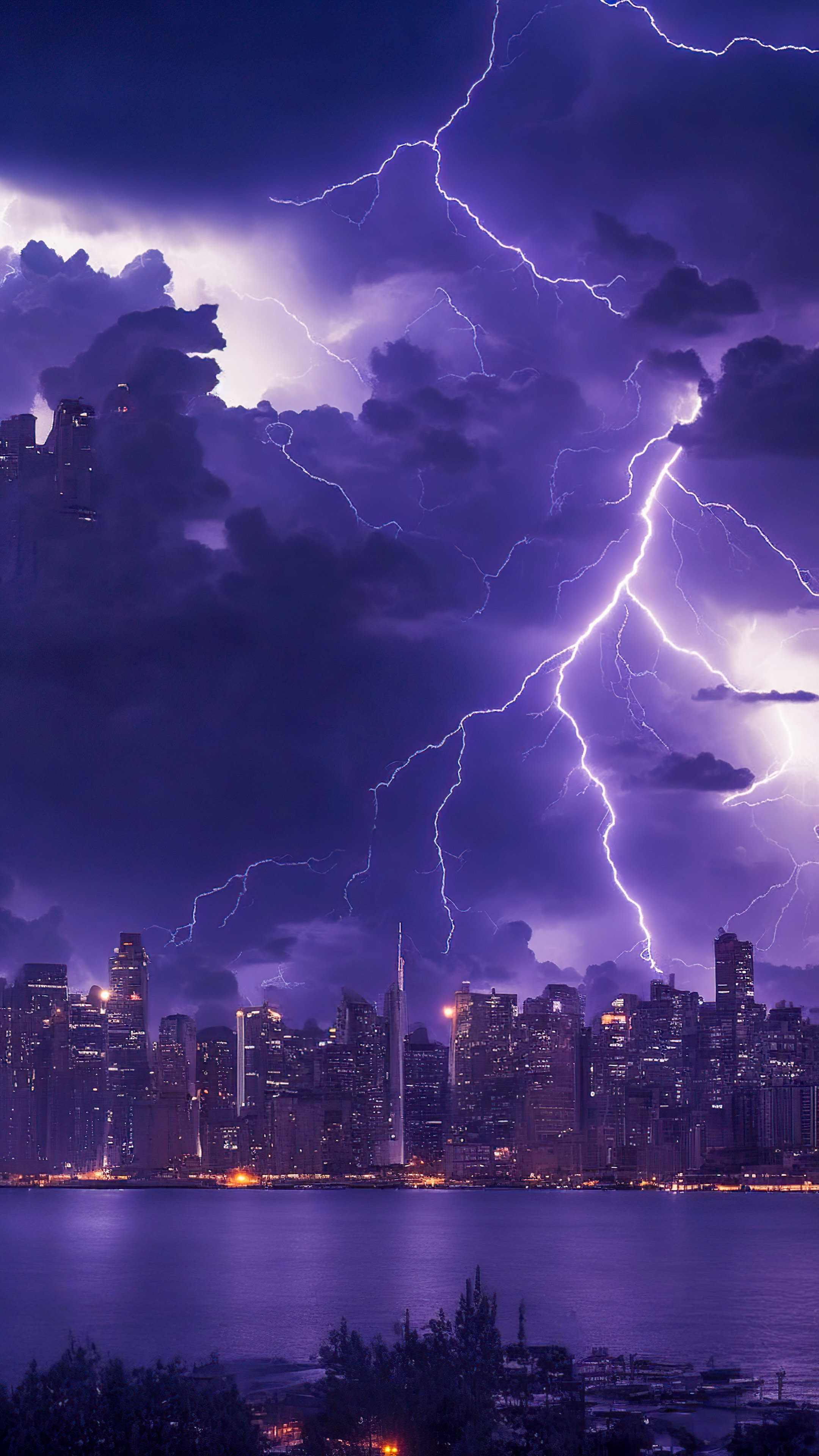 Capture the intensity of nature's drama with our night sky wallpaper, showcasing a thunderstorm over a city skyline, complete with electrifying lightning bolts.