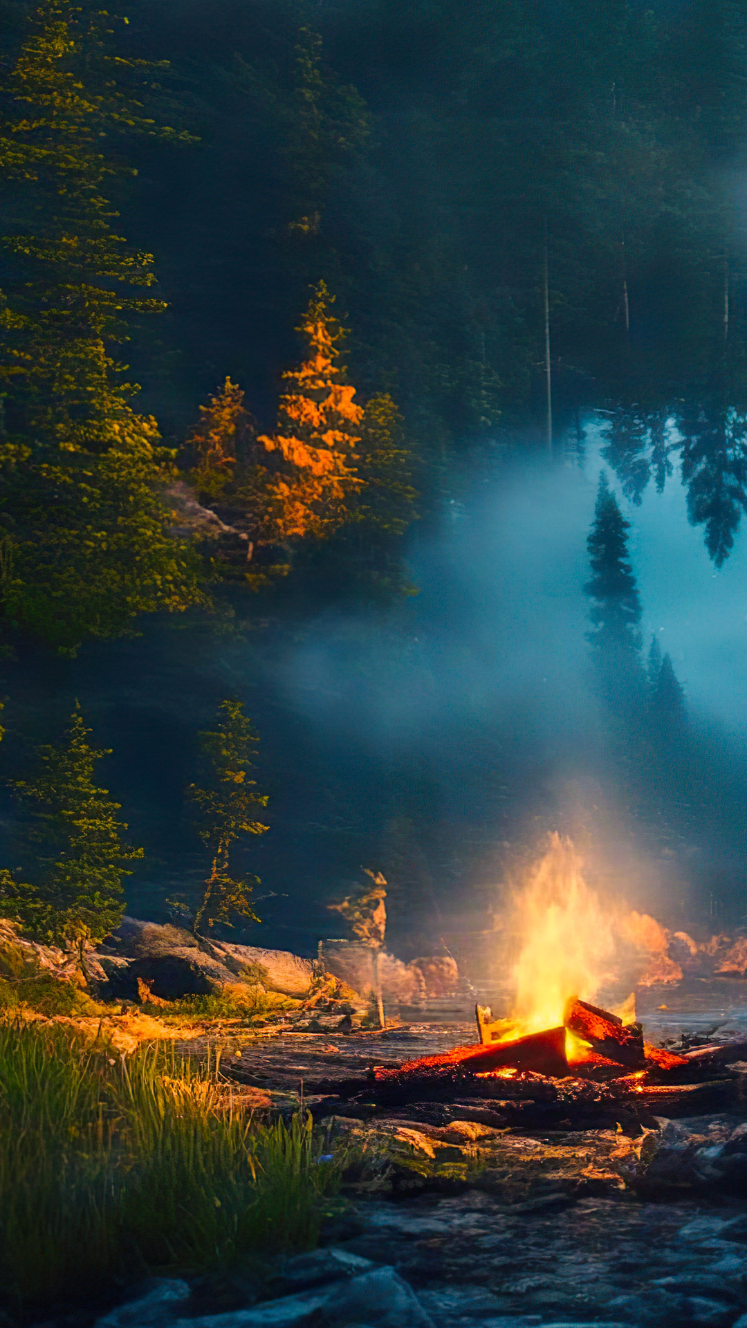 Perdez-vous dans la sérénité avec notre fond d'écran cool de paysages, dépeignant un campement paisible au bord d'un lac avec un feu de camp vacillant, entouré d'une nature boisée et sombre.